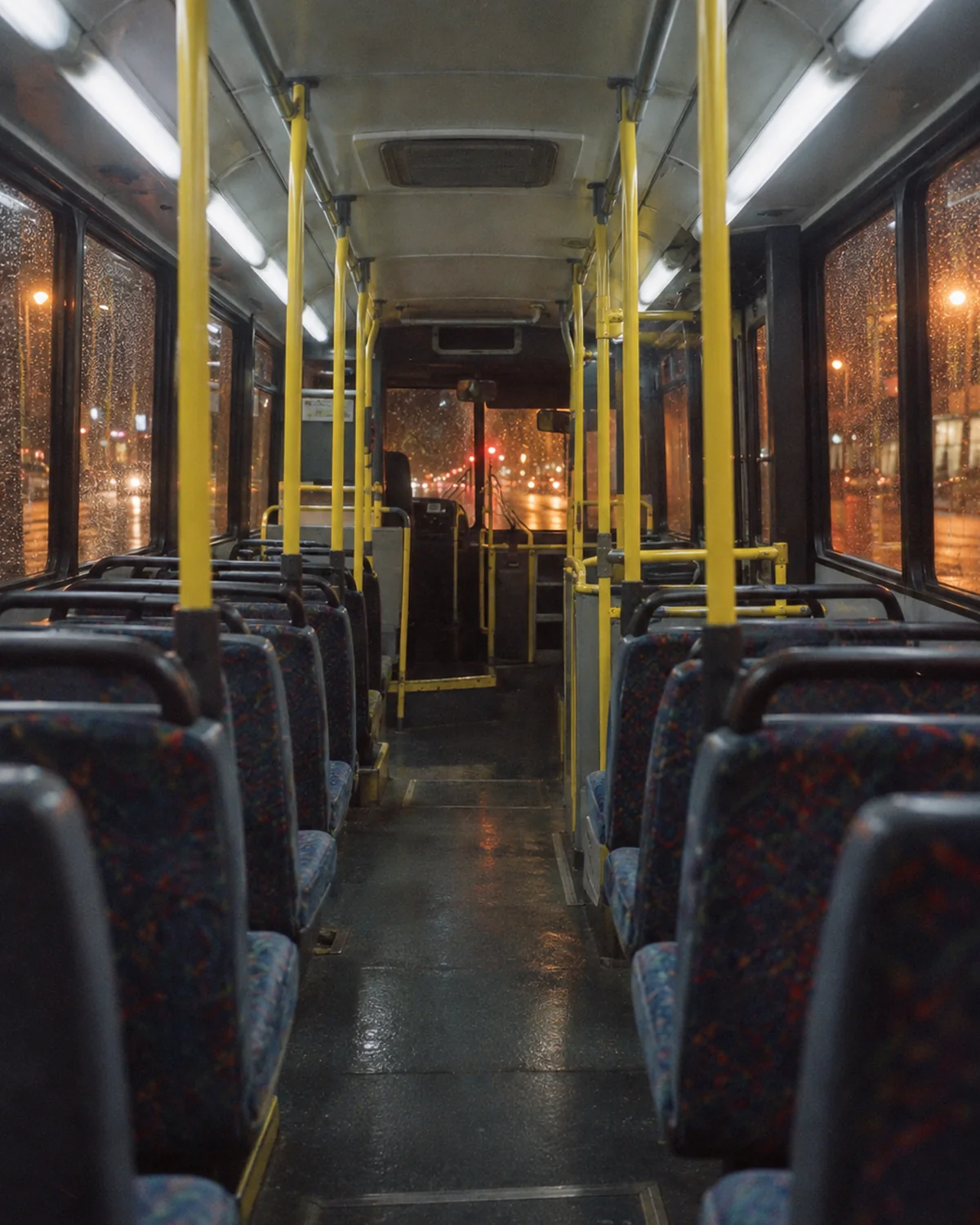 An empty night bus, lit inside, every seat free.